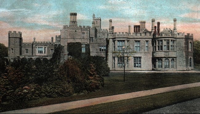 An old stately home. Old black and white photo that has been colourised.